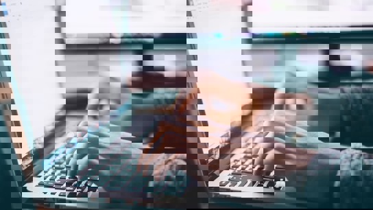 Närbild på händer som jobbar på en dator