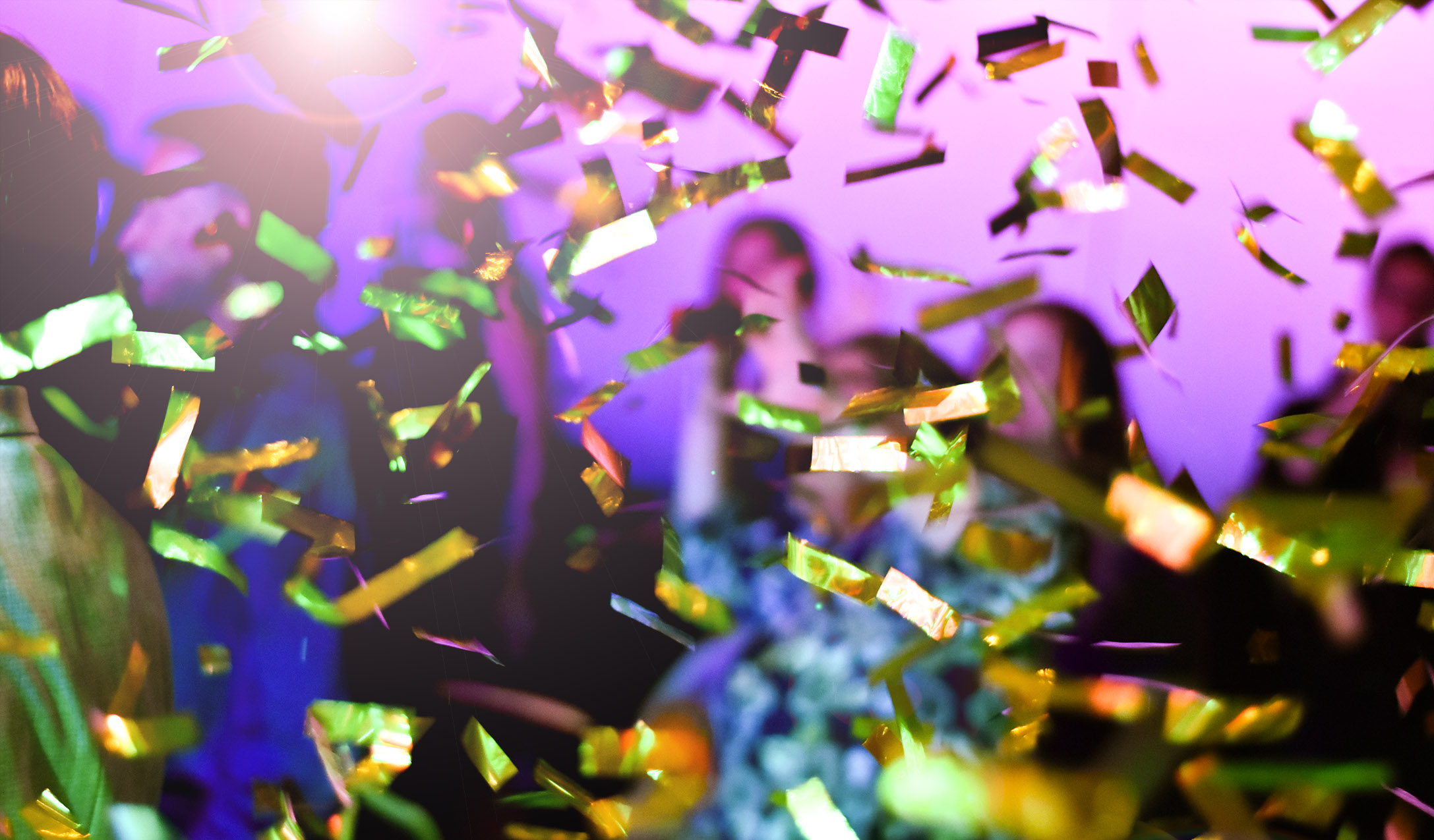 En grupp människor som står i ett rum med konfetti som täcker stora delar av bilden.