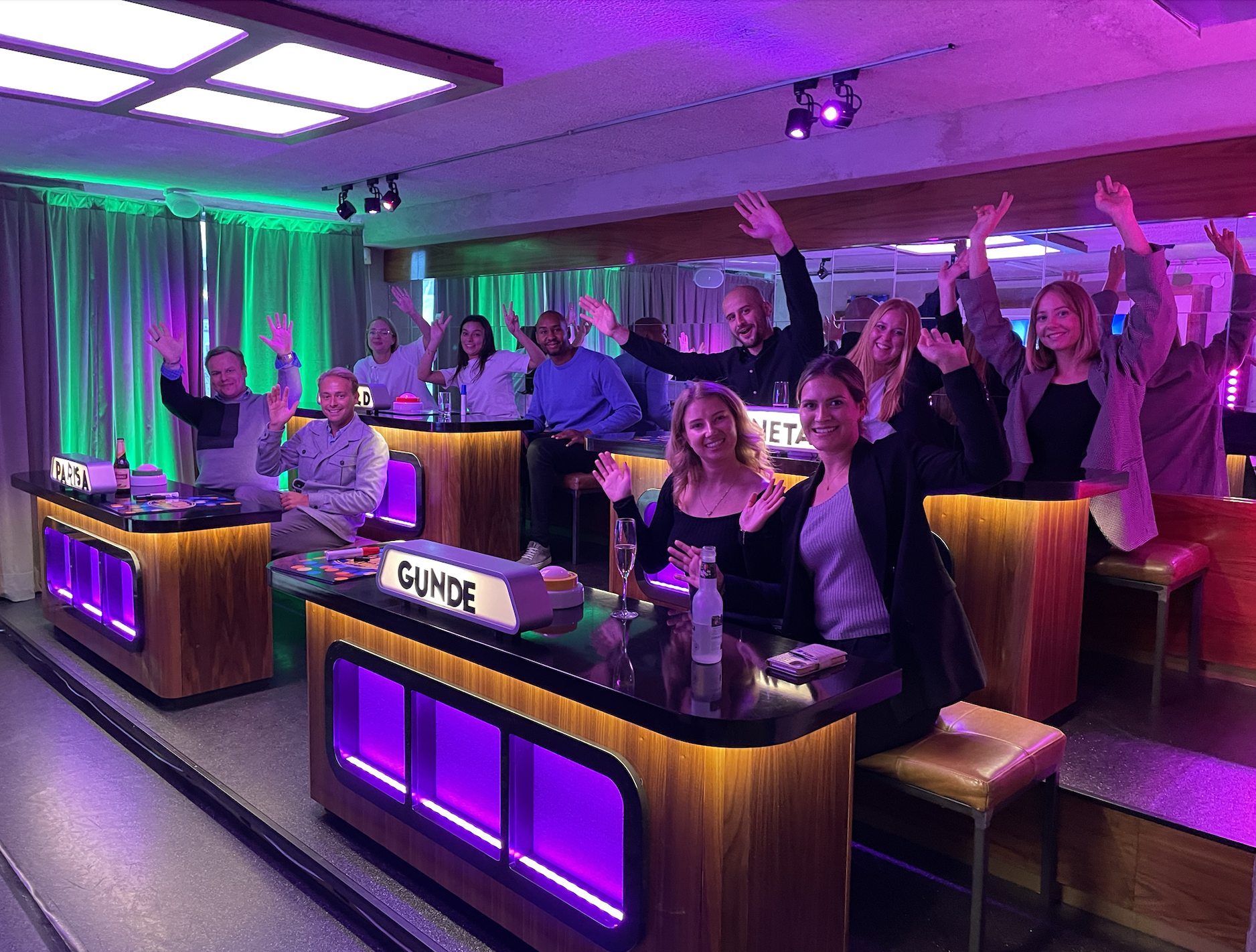 Grupp med människor på game show med neon ljus.